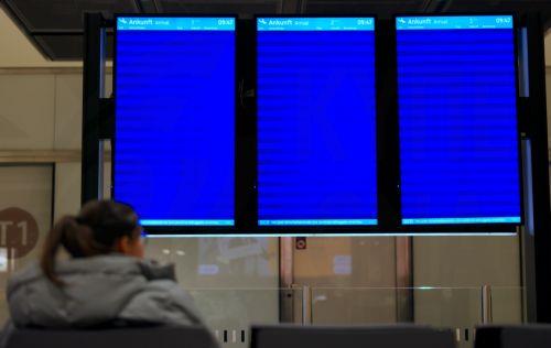 epa12829312 A woman sits in front of empty arrival boards at Terminal 1 of Berlin Brandenburg Airport in Schoenefeld, Germany, 18 March 2026. Passenger flight operations were completely suspended due to a one-day warning strike by the Verdi union. According to the airport operator, the strike affects 445 departures and arrivals and around 57,000 passengers....
