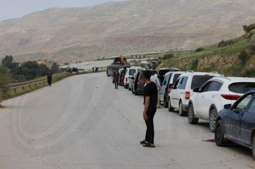 epa12829481 Palestinians wait to cross the Ein Shible checkpoint near the West Bank city of Nablus 18 March 2026.  EPA/ALAA BADARNEH
