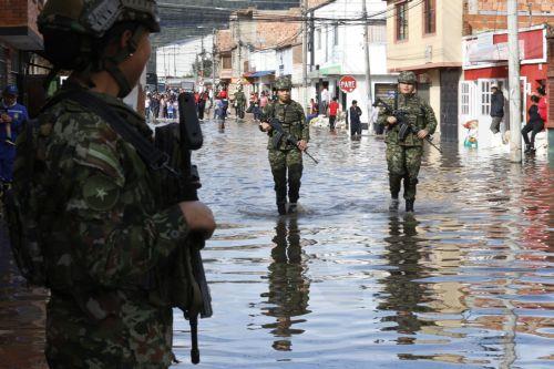 epa12834957 Members of the Colombian Army walk along a street flooded by heavy rains in Facatativa, Colombia, 19 March 2026. According to the mayor of Facatativa, Luis Carlos Casas, and local emergency agencies, heavy rains caused the Mancilla and San Rafael creeks to overflow and feed the Botello River, leading to severe flooding that affected more than...