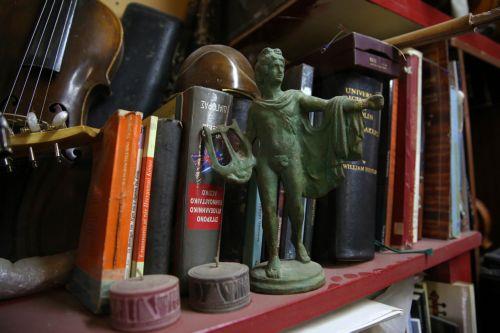 epa12838014 A figurine of the ancient god Apollo holding his lyre adorns the workshop of Nikolas Bras and his sons, Socrates and Hercules, where handmade stringed instruments have been crafted for 40 years, in Athens, Greece, 26 February 2026 (issued 21 March 2026). The customized shape of these hand-crafted instruments, their construction materials, the...