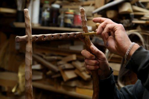 epa12838021 Hercules Bras carves the holes in order to install the tuning pegs on a lyre still in progress, in his father’s workshop, where handmade stringed instruments have been crafted for 40 years, in Athens, Greece, 26 February 2026 (issued 21 March 2026). The Bras family workshop, besides violin-family instruments, specializes also in making...