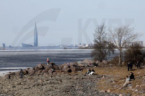 epa12841562 People relax on the shore of the Gulf of Finland on a sunny day in St. Petersburg, Russia, 22 March 2026. Temperatures in St. Petersburg, Russia's second largest city, reached eleven degrees Celsius.  EPA/ANATOLY MALTSEV