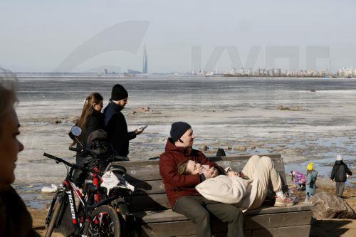 epa12841564 People relax on the shore of the Gulf of Finland on a sunny day in St. Petersburg, Russia, 22 March 2026. Temperatures in St. Petersburg, Russia's second largest city, reached eleven degrees Celsius.  EPA/ANATOLY MALTSEV