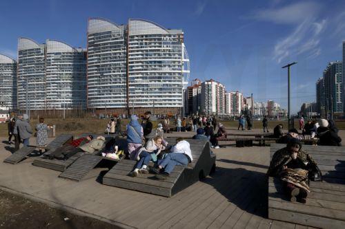 epa12841566 People relax on the shore of the Gulf of Finland on a sunny day in St. Petersburg, Russia, 22 March 2026. Temperatures in St. Petersburg, Russia's second largest city, reached eleven degrees Celsius.  EPA/ANATOLY MALTSEV
