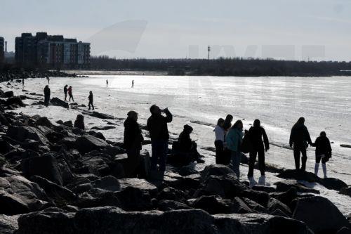 epa12841567 People relax on the shore of the Gulf of Finland on a sunny day in St. Petersburg, Russia, 22 March 2026. Temperatures in St. Petersburg, Russia's second largest city, reached eleven degrees Celsius.  EPA/ANATOLY MALTSEV