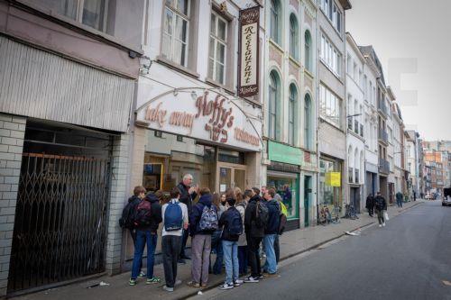 epa12843688 The owner of Hoffy's take-away restaurant looks on how students of a local school learn from a guide how to interact with the Jewish community in Antwerp, Belgium, 23 March 2026. The Belgian government announced on 16 March that it will deploy military personnel to reinforce the Federal Police to protect a number of synagogues and Jewish schools...