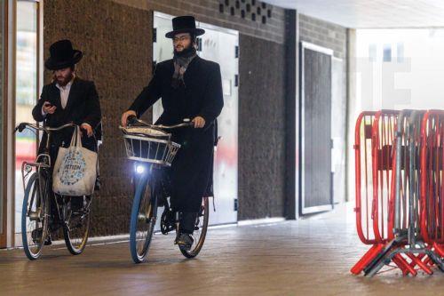 epa12843684 Members of the Jewish community ride their bikes in Antwerp, Belgium, 23 March 2026. The Belgian government announced on 16 March that it will deploy military personnel to reinforce the Federal Police to protect a number of synagogues and Jewish schools across the country following a series of antisemitic attacks in Europe.  EPA/OLIVIER MATTHYS