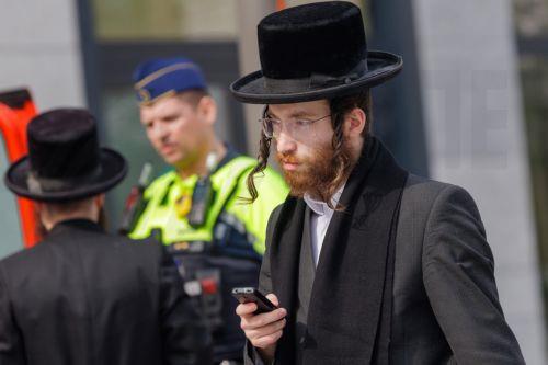 epa12843687 Members of the Jewish community interact with the police in Antwerp, Belgium, 23 March 2026. The Belgian government announced on 16 March that it will deploy military personnel to reinforce the Federal Police to protect a number of synagogues and Jewish schools across the country following a series of antisemitic attacks in Europe.  EPA/OLIVIER...