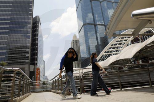 epa12859928 A Thai man protects himself from the sun during hot weather in Bangkok, Thailand, 30 March 2026. The Meteorological Department reports that Thailand is experiencing extreme heat and urges the public to avoid outdoor activity while the Digital Economy and Society Ministry warns the country's heat index is forecasted to soar to a health-dangerous...
