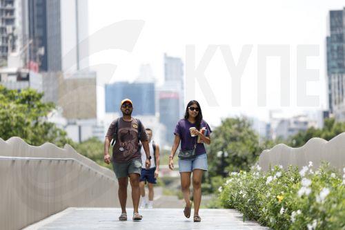 epa12859934 Foreign tourists walk outdoors during hot weather in Bangkok, Thailand, 30 March 2026. The Meteorological Department reports that Thailand is experiencing extreme heat and urges the public to avoid outdoor activity while the Digital Economy and Society Ministry warns the country's heat index is forecasted to soar to a health-dangerous level of...
