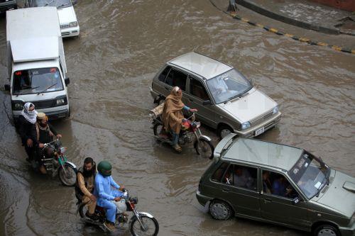 epa12860019 Vehicles drive along a flooded road during heavy rain in Peshawar, Pakistan, 30 March 2026. At least nine people were killed and several others injured after heavy rains and strong winds caused roof collapses in parts of Khyber Pakhtunkhwa and Punjab, with Bannu among the worst affected. Rescue efforts are ongoing, and authorities have warned of...