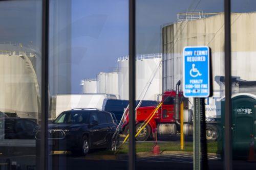 epa12862003 Fuel storage tanks holding gasoline, jet fuel, and diesel are reflected in a store window at the Newington fuel terminal in Lorton, Virginia, USA, 31 March 2026. The Iran war has raised average gas prices in the US above four dollars a gallon for the first time since 2022.  EPA/JIM LO SCALZO