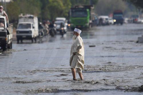 epa12866241 A man walks along a flooded road following heavy rainfall in Karachi, Pakistan, 02 April 2026. Heavy rain lashed Karachi and surrounding areas, prompting local authorities to declare an emergency as a westerly weather system brought intermittent showers, strong winds, and isolated heavy downpours across the city.  EPA/SHAHZAIB AKBER