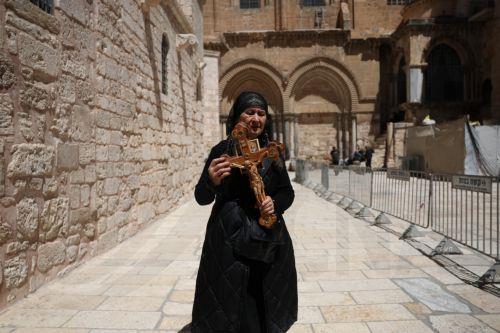 epa12879948 A worshipper carries a cross as she attends the Holy Friday procession at the Church of the Holy Sepulchre in the Old City of Jerusalem, 10 April 2026. Israel lifted restrictions on gatherings of people as Iran, the US, and Israel brokered a two-week ceasefire on 07 April 2026.  EPA/ABIR SULTAN