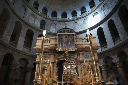 epa12879957 A monk pours oil at the tomb of Christ as worshippers attend the Holy Friday procession at the Church of the Holy Sepulchre in the Old City of Jerusalem, 10 April 2026. Israel lifted restrictions on gatherings of people as Iran, the US, and Israel brokered a two-week ceasefire on 07 April 2026.  EPA/ABIR SULTAN