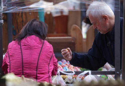 epa12880094 A man picks hand-painted Easter eggs for sale at a farmers market in Belgrade, Serbia, 10 April 2026. Orthodox Serbs will celebrate Easter on 12 April 2026.  EPA/ANDREJ CUKIC