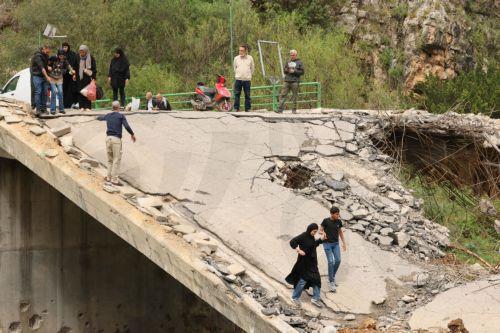 epa12900342 Displaced people walk across a destroyed bridge as they return to their villages, in the village of Tayr Felsay, in southern Lebanon, 19 April 2026. Israel and Lebanon have agreed to a 10-day ceasefire, which went into effect at midnight on 16 April.  EPA/WAEL HAMZEH