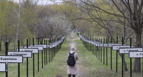 epa12910970 A visitor walks amongst signs with the names of abandoned villages as a result of the Chernobyl disaster in Chernobyl, Ukraine, 23 April 2026 (issued 24 April 2026). Ukraine will mark the 40th anniversary of the Chernobyl disaster on 26 April 2026. The explosion of reactor 4 of the Chernobyl nuclear power plant in the early hours of 26 April...