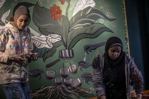 epa12922458 Palestinian Joud Mohammed (R), 18, and Rahaf Al-Halabi (L), 18, paint together inside a small cafe in Gaza City, 29 April 2026. The two teenagers use their artwork as a means of self-expression and to provide financial support for their families amid ongoing economic hardship. With Gaza's educational system largely paralyzed since the outbreak...