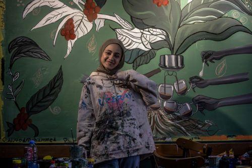 epa12922484 Palestinian Rahaf Al-Halabi, 18, poses for a photograph inside a small cafe in Gaza City, 29 April 2026. Palestinian teenagers Joud Mohammed and Rahaf Al-Halabi use their artwork as a means of self-expression and to provide financial support for their families amid ongoing economic hardship. With Gaza's educational system largely paralyzed since...