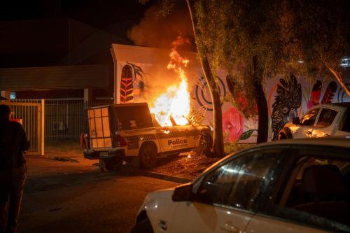 epa12925503 A police vehicle burns as community members clash with authorities outside Alice Springs Hospital in Alice Springs, Australia, 30 April 2026 (issued 01 May 2026). The riot erupted following the arrest of a man, who is accused of the abduction and murder of five-year-old Kumanjayi Little Baby.  EPA/RHETT HAMMERTON  AUSTRALIA AND NEW ZEALAND OUT