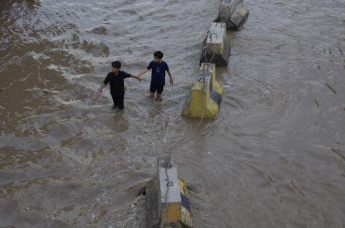 epa12929028 People wade through a flooded street following torrential rainfall in Sana'a, Yemen, 02 May 2026. Yemen's National Center of Meteorology and Early Warning has warned of further heavy rains and possible flooding across much of the country.  EPA/YAHYA ARHAB
