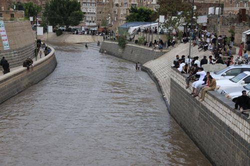 epa12929034 People sit beside a flooded street following torrential rainfall in Sana'a, Yemen, 02 May 2026. Yemen's National Center of Meteorology and Early Warning has warned of further heavy rains and possible flooding across much of the country.  EPA/YAHYA ARHAB