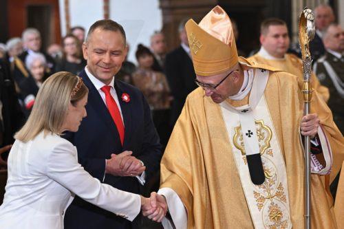epa12929433 Polish President Karol Nawrocki (C), First Lady Marta Nawrocka (L) and Metropolitan Archbishop of Warsaw Adrian Galbas (R) during a Holy Mass for the Homeland as part of 3rd May Constitution Day celebrations at the Archcathedral of St. John the Baptist in Warsaw, Poland, 03 May 2026The 03 May National Holiday commemorates the adoption of the 03...