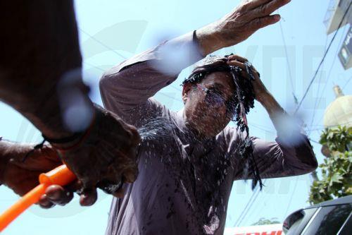 epa12931539 A volunteer sprays water on people during a heatwave in Karachi, Pakistan, 04 May 2026. The Pakistan Meteorological Department has issued a heatwave alert for Karachi, warning that temperatures could rise to around 41 degrees Celsius in the coming days.  EPA/REHAN KHAN