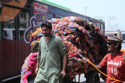 epa12931540 A volunteer sprays water on people during a heatwave in Karachi, Pakistan, 04 May 2026. The Pakistan Meteorological Department has issued a heatwave alert for Karachi, warning that temperatures could rise to around 41 degrees Celsius in the coming days.  EPA/REHAN KHAN