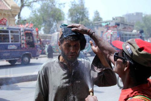 epa12931542 A volunteer sprays water on people during a heatwave in Karachi, Pakistan, 04 May 2026. The Pakistan Meteorological Department has issued a heatwave alert for Karachi, warning that temperatures could rise to around 41 degrees Celsius in the coming days.  EPA/REHAN KHAN