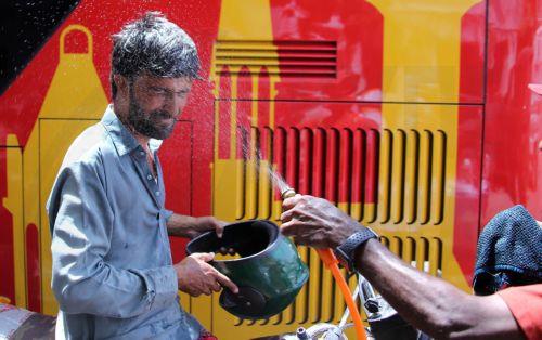 epa12931543 A volunteer sprays water on people during a heatwave in Karachi, Pakistan, 04 May 2026. The Pakistan Meteorological Department has issued a heatwave alert for Karachi, warning that temperatures could rise to around 41 degrees Celsius in the coming days.  EPA/REHAN KHAN