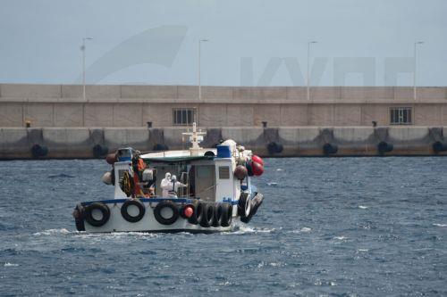 epa12947801 Personnel wearing protective gear on a support vessel head toward the MV Hondius cruise ship, which was affected by several hantavirus cases, at the Port of Granadilla de Abona in Tenerife, Spain, 11 May 2026. Authorities prepared to disembark the last passengers and crew members, who were expected to be repatriated from Tenerife South Airport. ...