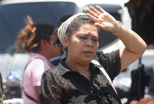 epa12952056 A woman shields her face to provide relief during a heat wave, which is causing 'extreme temperatures' exceeding 40 degrees Celsius, in San Salvador, El Salvador, 12 May 2026.  EPA/Javier Aparicio