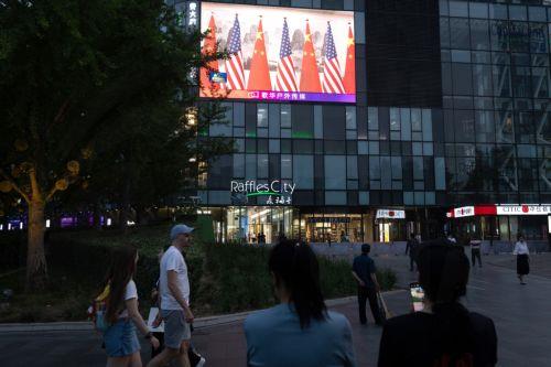 epa12957047 People walk in front of a TV broadcast during US President Donald Trum's visit, in Beijing, China, 14 May 2026. US President Trump is in Beijing for a high-stakes state visit running through 15 May, marking his first return to the mainland since 2017.  EPA/JESSICA LEE