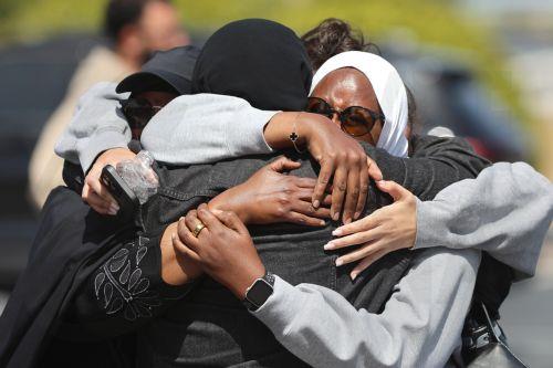 epa12972649 Members of the muslim community in San Diego embrace a block away from where an active shooting incident took place in San Diego, California, USA, 18 May 2026. Police agencies from across San Diego County responded to an active shooter incident at the Islamic Center of San Diego in the Clairemont neighborhood. Three people were killed, including...