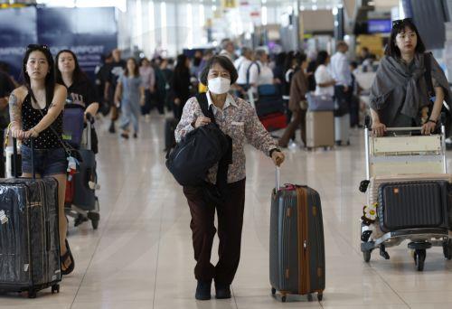 epa12977388 An international flight passenger wears a protective face mask at Suvarnabhumi Airport in Samut Prakan province, Thailand, 20 May 2026. Thailand's Public Health Ministry has tightened its health surveillance measures to closely monitor travellers arriving from countries at high risk for an Ebola virus disease outbreak, aiming to prevent imported...