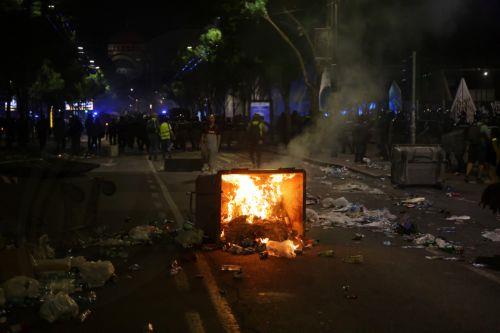 epa12988492 An overturned dumpster burns as riot police officers take positions after a mass student-led anti-government rally in Belgrade, Serbia, 23 May 2026. Thousands gathered to ramp up pressure on the government and demand early parliamentary elections. The political movement originally erupted across the country following the November 2024 canopy...