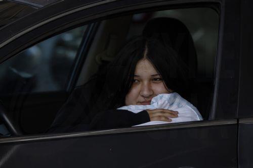 epa12989307 Jules Olivas rests in her car at JFK High School evacuation center after evacuating her home due to a chemical leak from a large storage tank at the GKN Aerospace facility; in Garden Grove, California USA, 23 May 2026. A failing 34,000-gallon tank of methyl methacrylate overheated, prompting tens of thousands of evacuations in the Garden Grove...