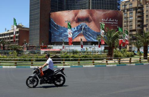 epa12992438 People drive in front of a large anti-US billboard featuring US President Donald Trump and the Strait of Hormuz at Valiasr Square in Tehran, Iran, 25 May 2026. The US and Iran voiced optimism regarding a potential peace agreement and the reopening of the Strait of Hormuz, though both sides emphasized that no such deal has been reached yet. ...