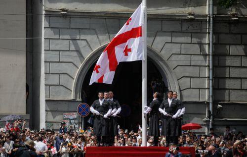 epa12994474 Georgian men dressed in national costumes raise the Georgian national flag during a military parade marking the country's 108th Independence Day in Tbilisi, Georgia, 26 May 2026. Georgia declared its independence from Russia on 26 May 1918.  EPA/DAVID MDZINARISHVILI