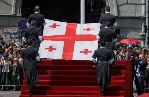 epa12994475 Georgian men dressed in national costumes carry the Georgian national flag during a military parade marking the country's 108th Independence Day in Tbilisi, Georgia, 26 May 2026. Georgia declared its independence from Russia on 26 May 1918.  EPA/DAVID MDZINARISHVILI