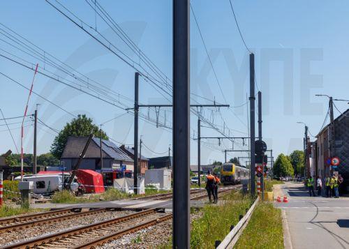 epa12994702 Police and members of emergency services operate at the scene of a collision between a train and a school minibus at a railroad crossing in Buggenhout, Belgium, 26 May 2026. According to statements from Belgian Mobility Minister Jean-Luc Crucke and local authorities, four people, including two children, were confirmed dead and several others...