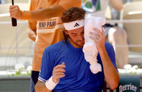 epa12994974 Stefanos Tsitsipas of Greece holds a cold towel to his face to cool off during his 1st round match against Alexandre Mueller of France at the French Open Grand Slam tennis tournament at Roland Garros in Paris, France, 26 May 2026.  EPA/YOAN VALAT