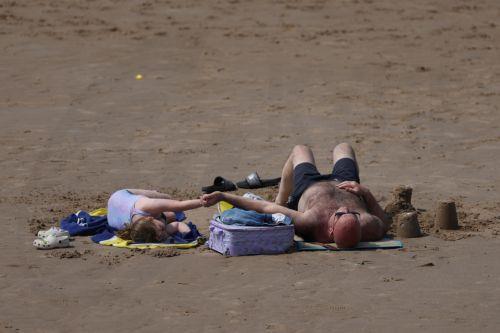epa12997819 People lie on the beach at the seaside resort of Blackpool, Britain, 27 May 2026. The UK is experiencing a record-breaking heatwave, with temperatures exceeding 35 degrees Celsius, marking the hottest May on record.  EPA/ADAM VAUGHAN