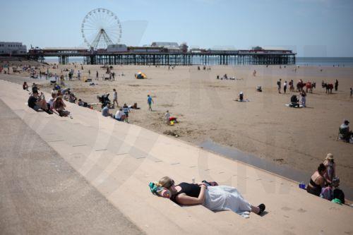 epa12997821 A person lies on the promenade steps at the seaside resort of Blackpool, Britain, 27 May 2026. The UK is experiencing a record-breaking heatwave, with temperatures exceeding 35 degrees Celsius, marking the hottest May on record.  EPA/ADAM VAUGHAN