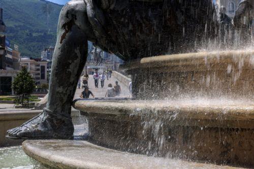 epaselect epa12997730 People walk past a fountain during a hot day in the center of Skopje, Republic of North Macedonia, 27 May 2026. A heatwave has hit North Macedonia, with temperatures rising above 30 degrees Celsius.  EPA/GEORGI LICOVSKI