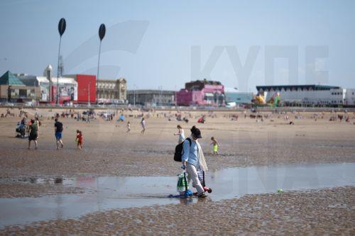 epa12997961 A person walks along the beach in Blackpool, Britain, 27 May 2026. The UK is experiencing a record-breaking heatwave, with temperatures exceeding 35 degrees Celsius, making May the hottest on record.  EPA/ADAM VAUGHAN
