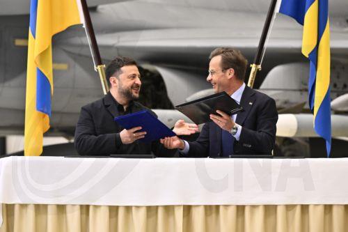 epa13000013 Ukrainian President Volodymyr Zelensky (L) and Swedish Prime Minister Ulf Kristersson exchange documents as they give a joint news conference at the F16 air flotilla in Uppsala, Sweden, 28 May 2026. Sweden is donating 16 Gripen aircraft to Ukraine. Furthermore, Ukraine is to purchase up to 20 planes of the new Gripen E/F model, according to the...