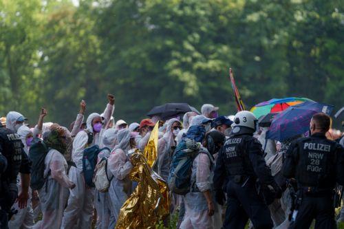 epa13003750 Protesters are escorted from a sunlit area of the plant grounds toward a shaded area in Gelsenkirchen, Germany, 29 May 2026. Members of the organization 'Ende Gelaende' entered the plant's grounds during a protest action, leading to a blockade of the facility.  EPA/CHRISTOPH RUTENKOLK